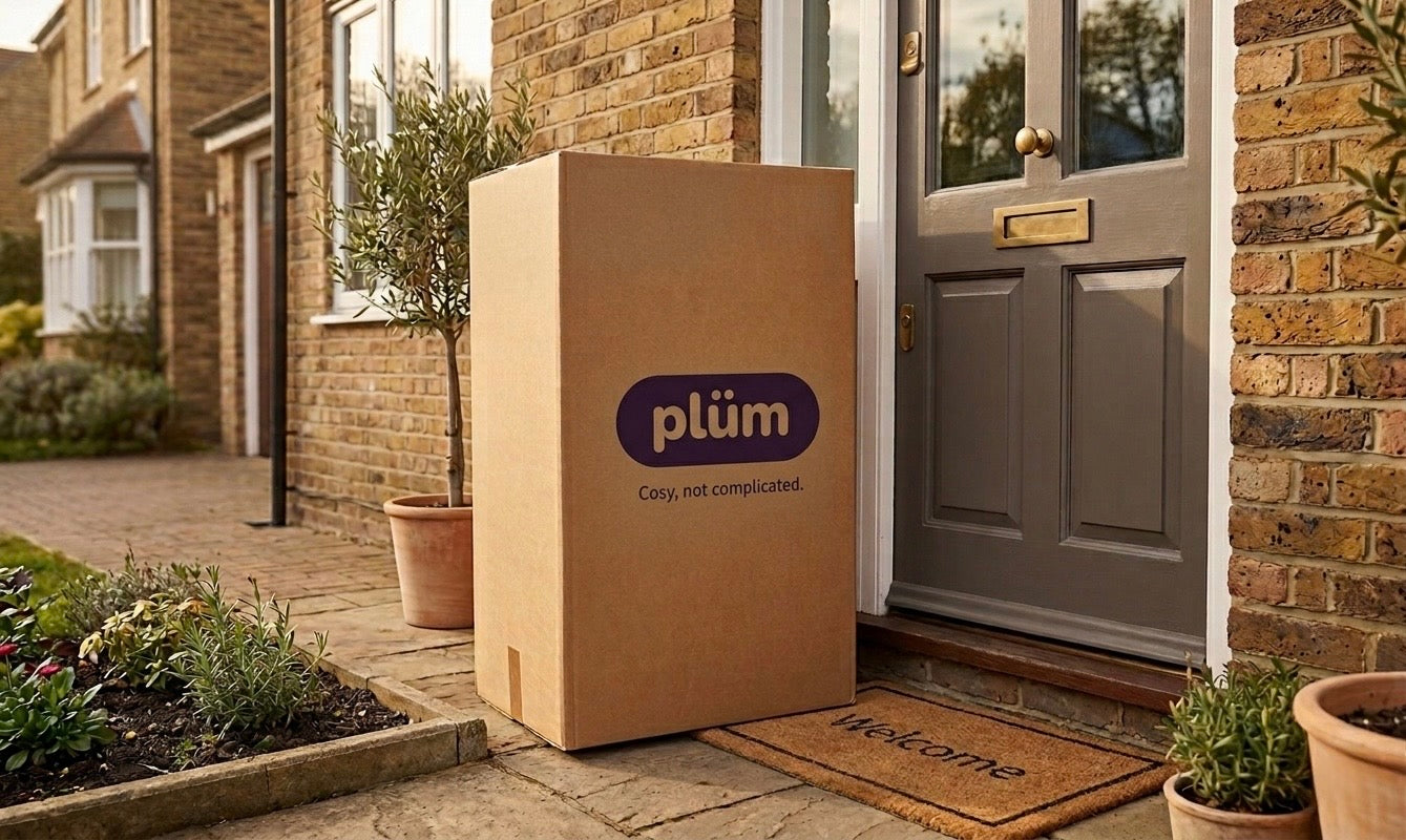 Cardboard box with plüm logo outside a house door